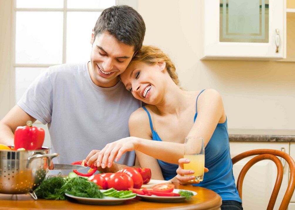 donna e uomo che preparano le verdure per aumentare la potenza